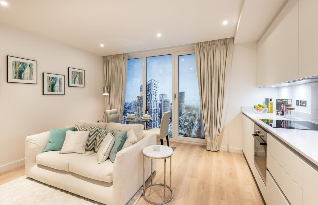 Show flat living room at Goodman Fields with recessed downlights and city views